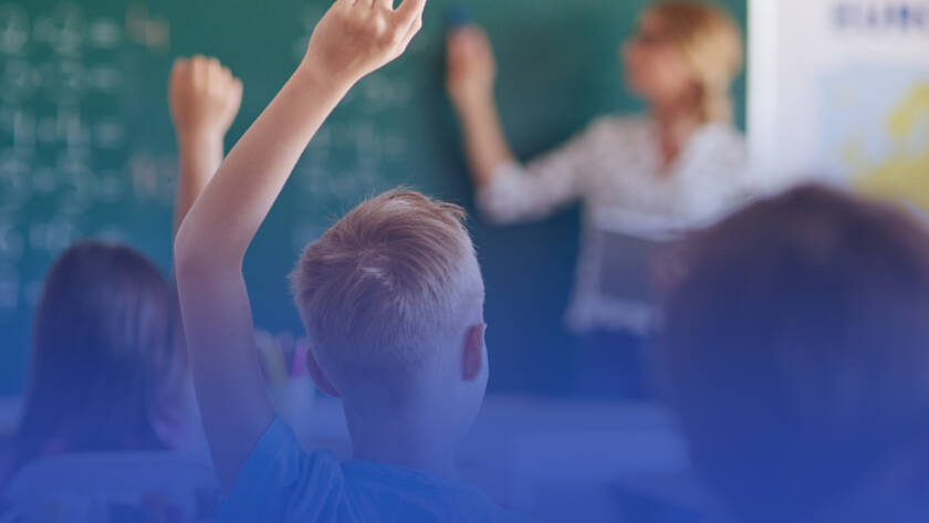 crianças levantando a mão em sala de aula para tirar dúvidas com a professora