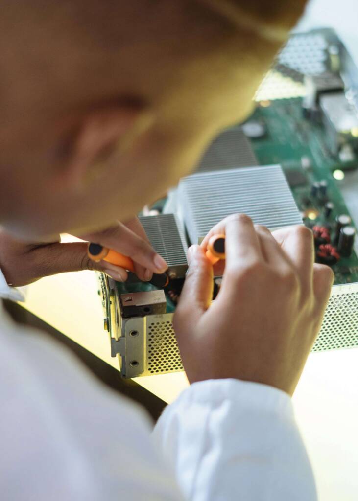 Imagem de um homem fazendo um reparo técnico em um dispositivo eletrônico.