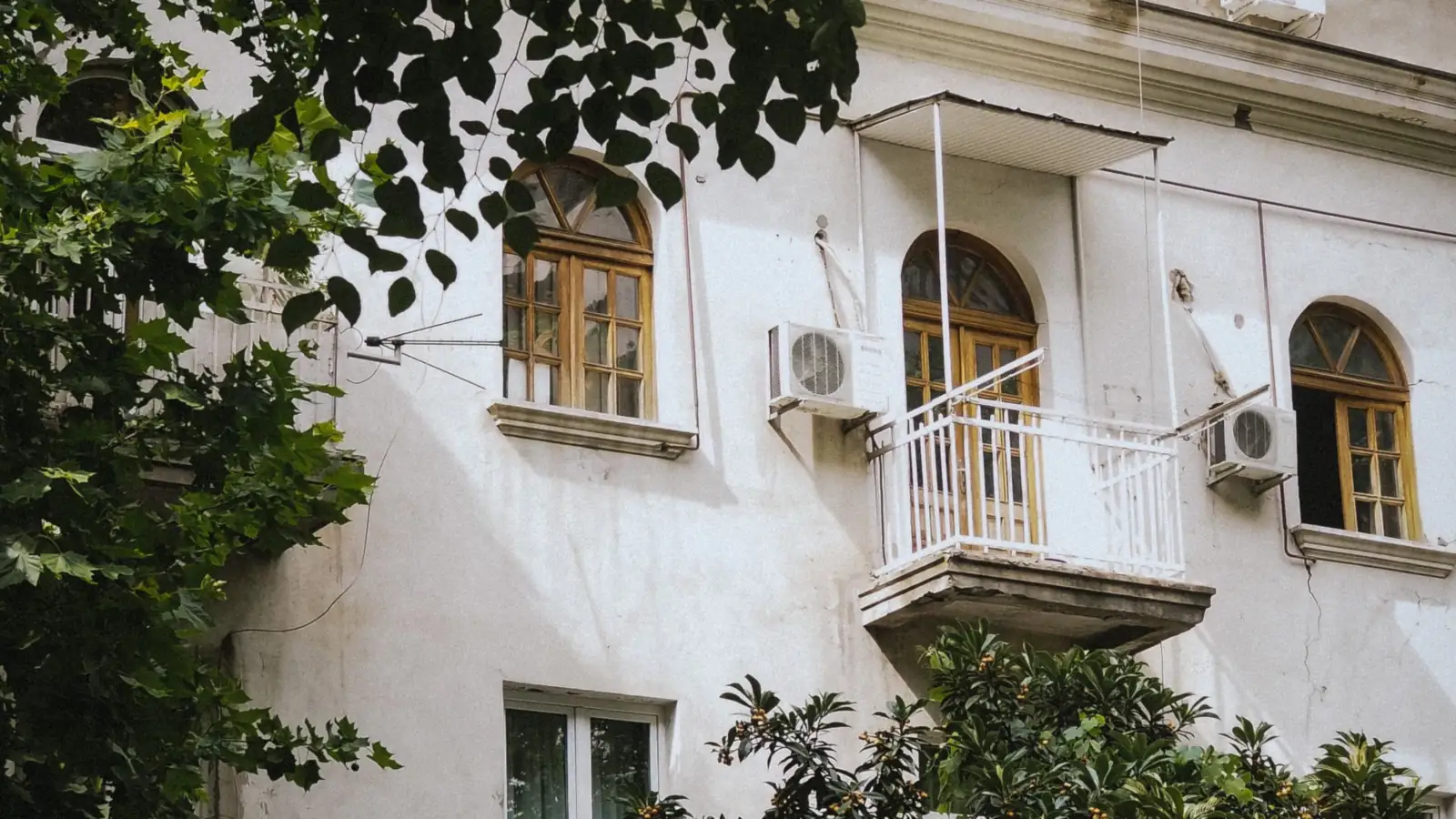 Fachada de condomínio com árvores e jardim, espaço cuidado em conjunto pelos moradores de um condomínio afetivo
