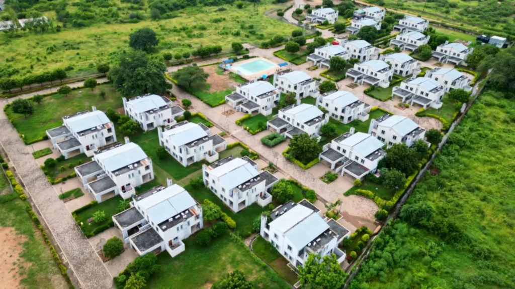 Vista aérea de condomínio com casas, área verde e muro no limite do terreno, perímetro que a segurança precisa cobrir